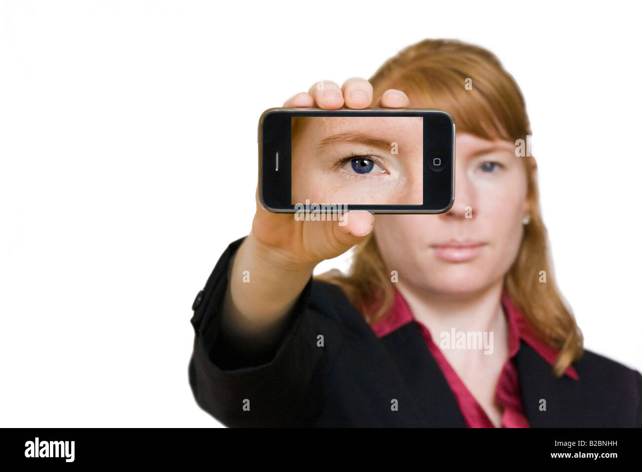 A female model in business attire displays an Apple 3G iPhone Stock Photo