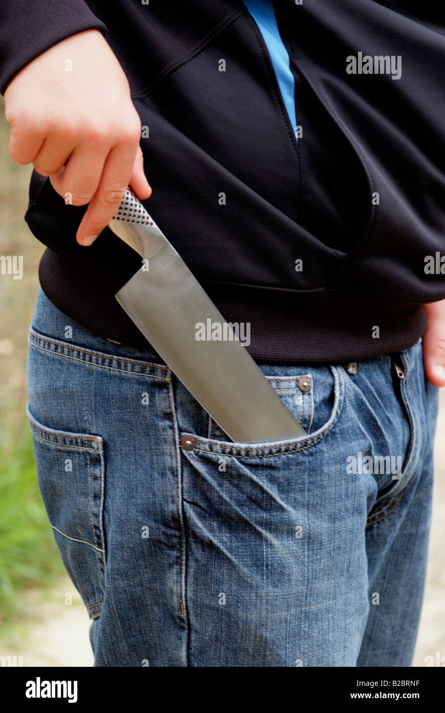 Knife crime boys hand holding a kitchen knife A meat cleaver Stock