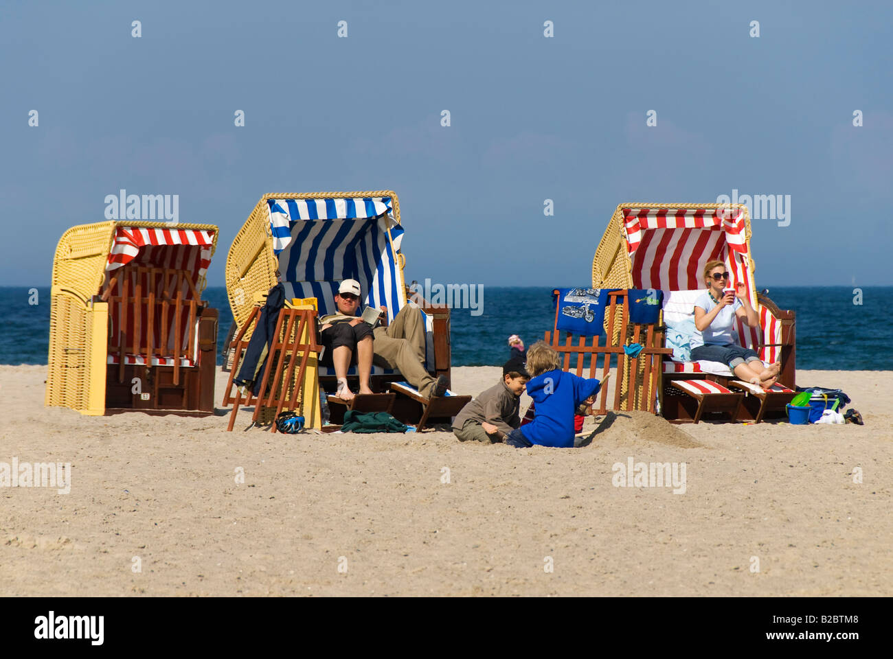 Tourists relaxing in roofed wicker beach chairs, Travemuende Beach, Schleswig-Holstein, Germany, Europe Stock Photo