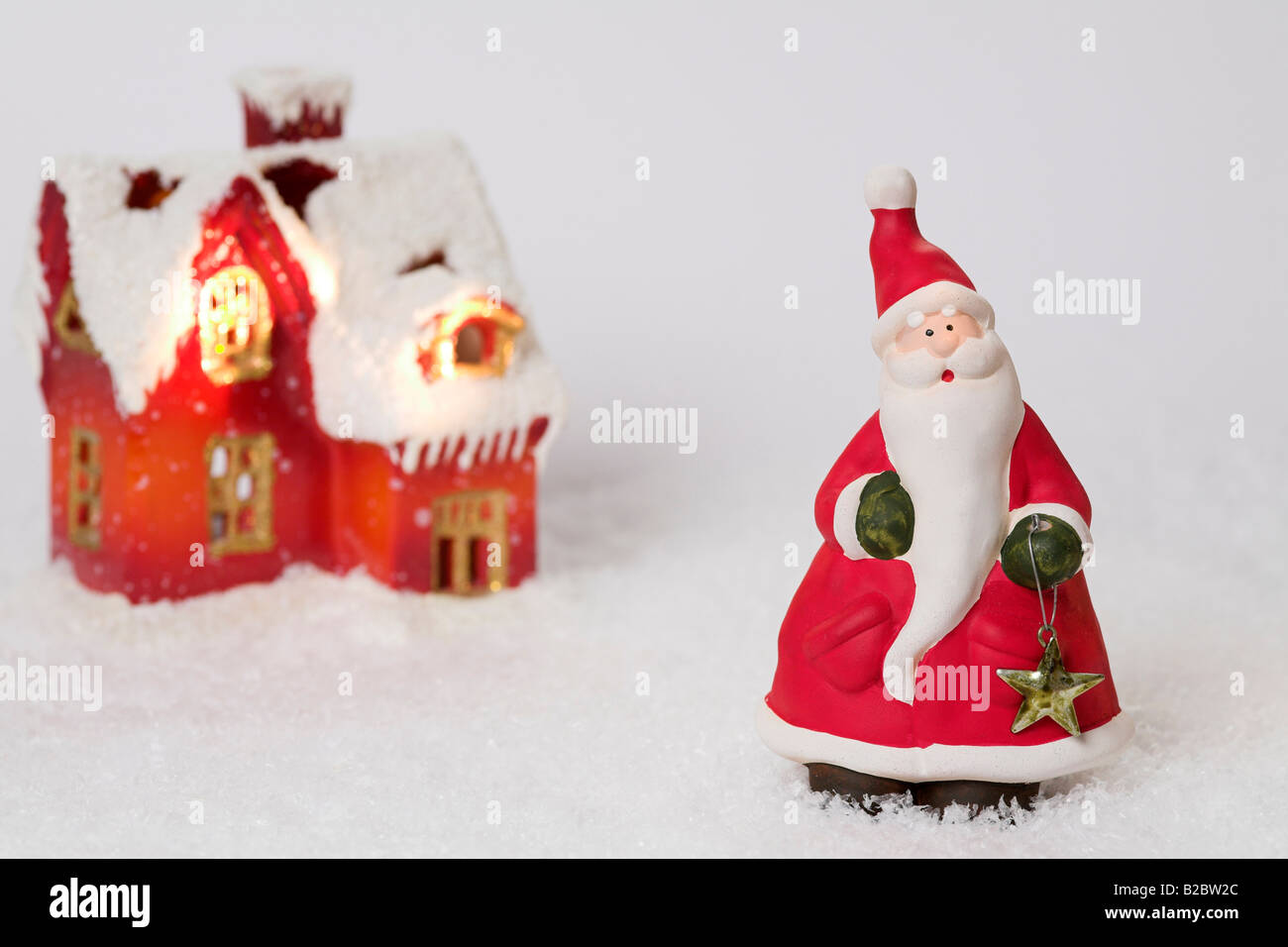 Christmas house and Father Christmas made of clay on artificial snow Stock Photo