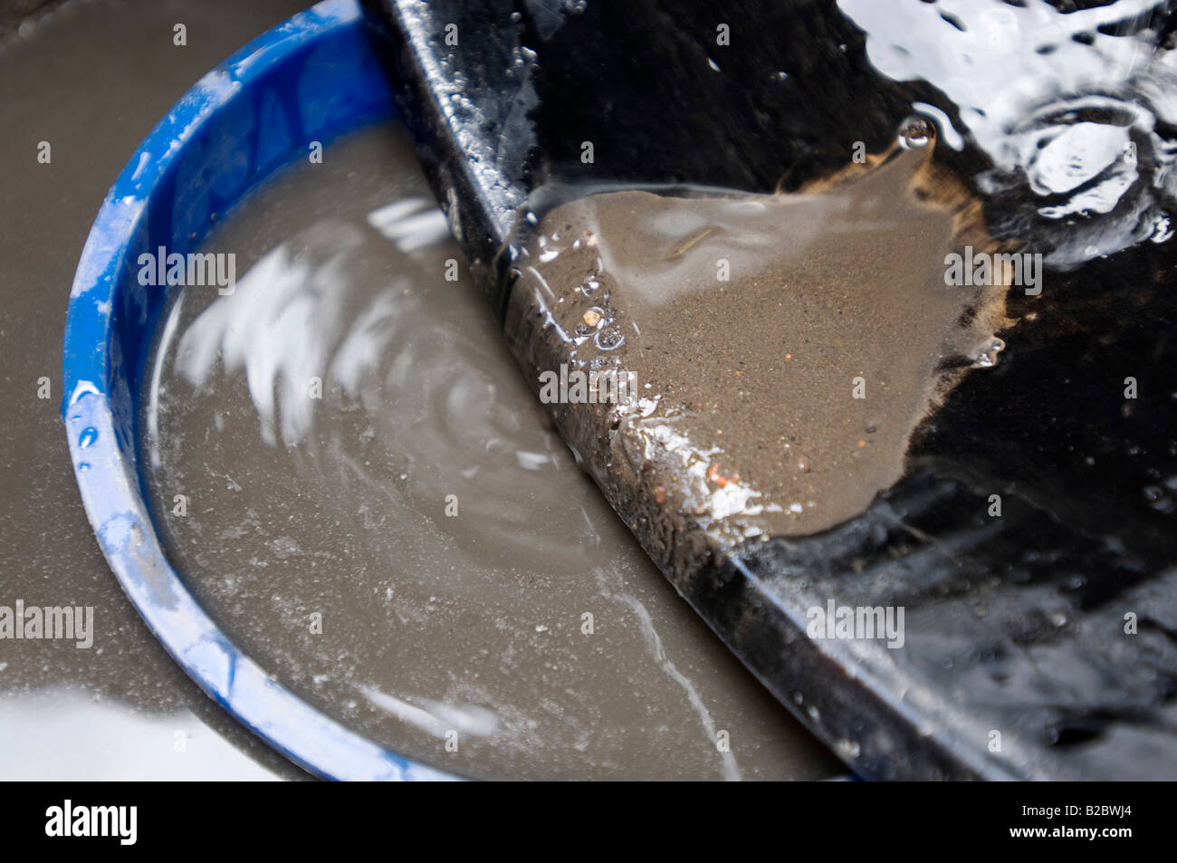 Many slum inhabitants live from recycling old industrial waste. Here a daily paid worker is washing poisonous industrial slag s Stock Photo