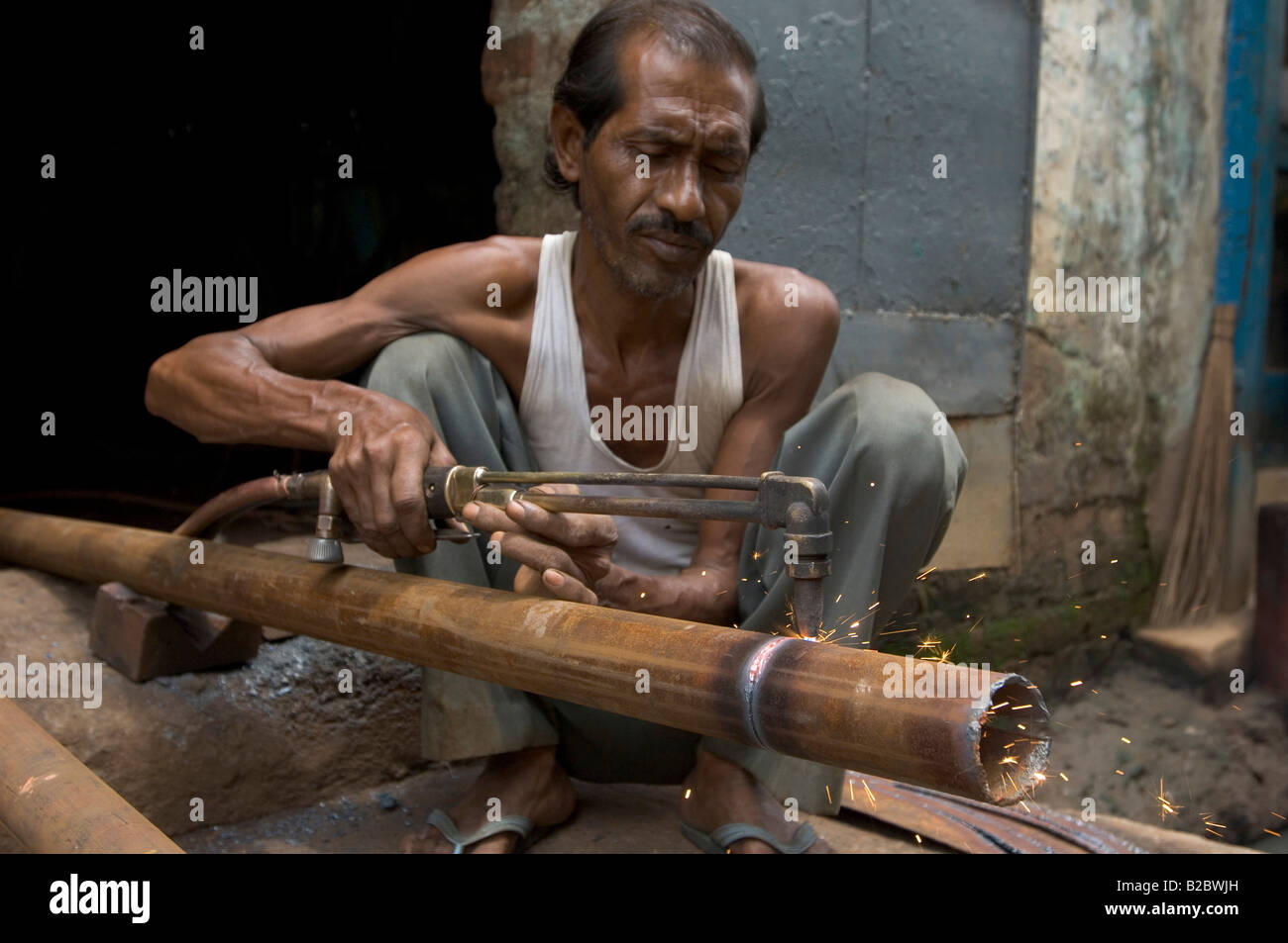Indian steelworker. For work that in Europe would be carried out by a computer controlled machine you only need a worker with a Stock Photo