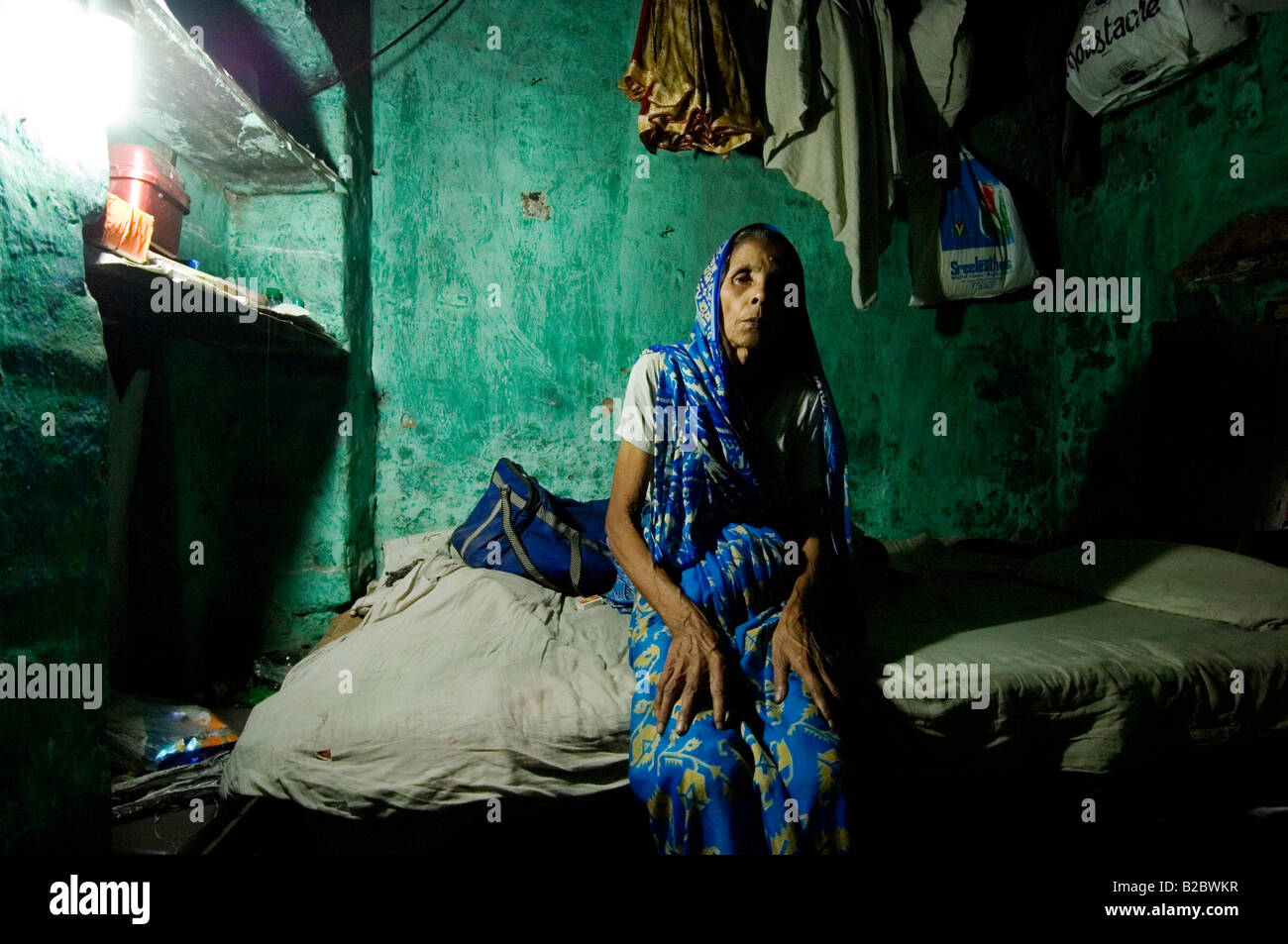 Shushila Devi, 70, has tuberculosis and lives in a small, dark room that resembles a cave. She is a widow and her daughter is m Stock Photo