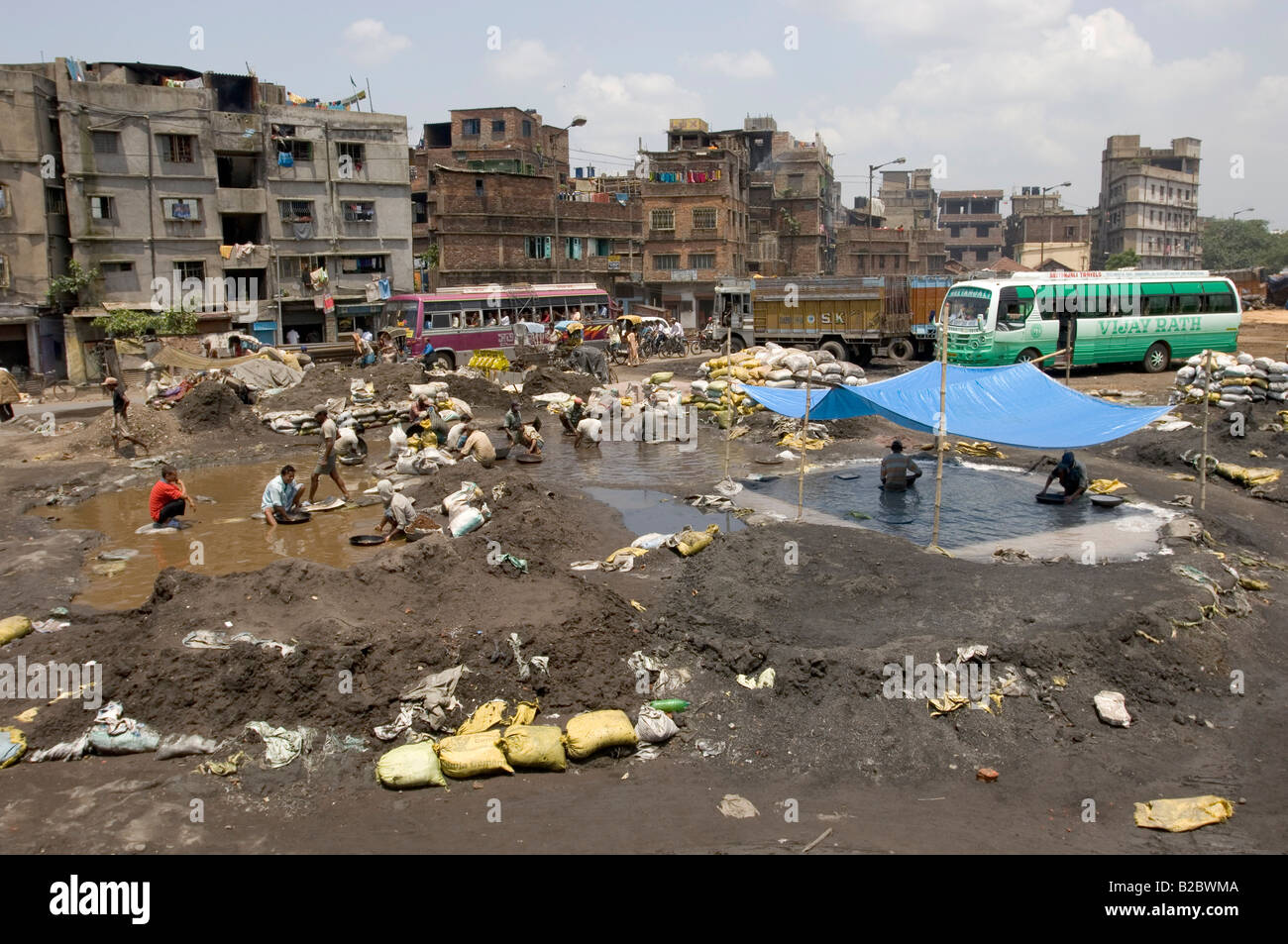 Many slum dwellers live off recycling old industrial waste. In this case, poisonous, metalliferous industrial slag is being rin Stock Photo