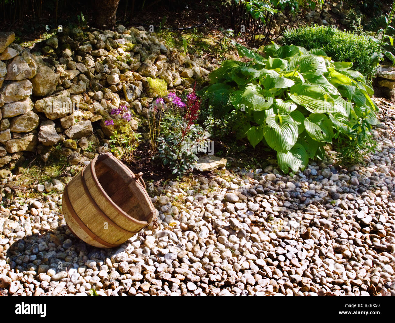 Old wooden vessel in a gravel garden in Jardin Agapanthe Normandy France EU Stock Photo