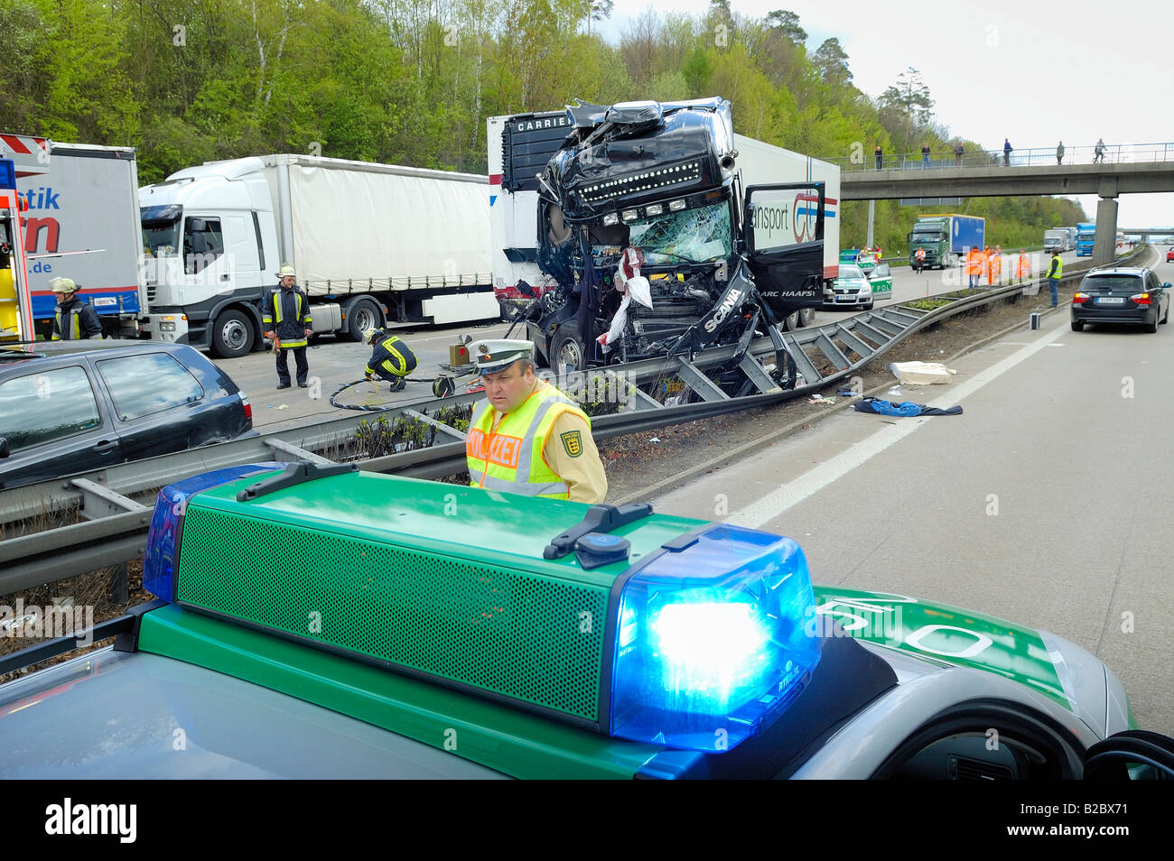 Police vehicle on the left lane of the opposite carriageway to the major lorry accident on the A8 Motorway, in the direction of Stock Photo