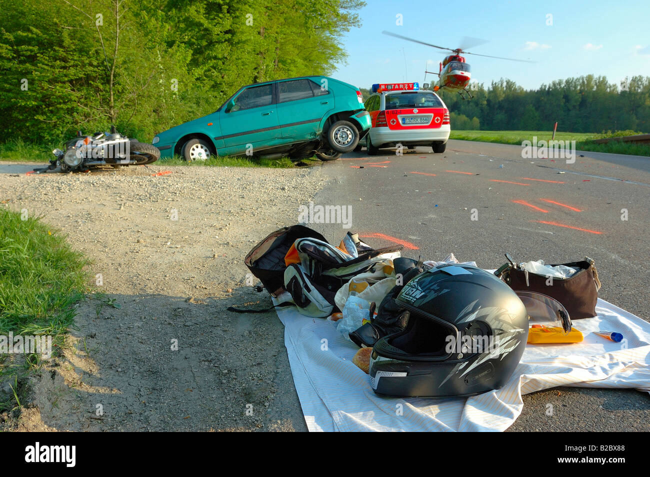 Scene of a car and motorcycle accident, rescue helicopter lifting off carrying a female victim, she died the following morning  Stock Photo