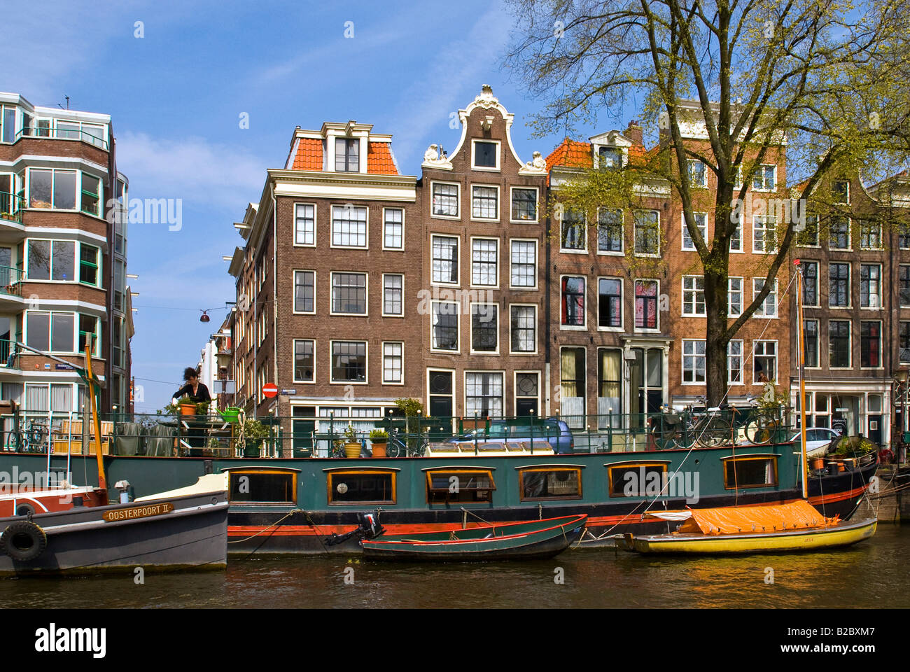 Houseboats in front of buildings along the canals in Amsterdam, Holland, the Netherlands, Europe Stock Photo