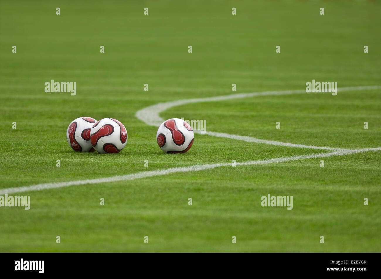 Three footballs on a soccer field, Unterhaching, Bavaria, Germany, Europe Stock Photo