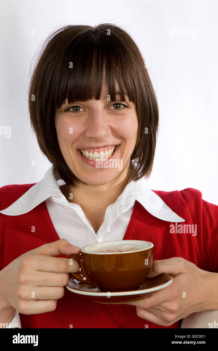 Grinning twenty-year-old woman drinking cappucino Stock Photo