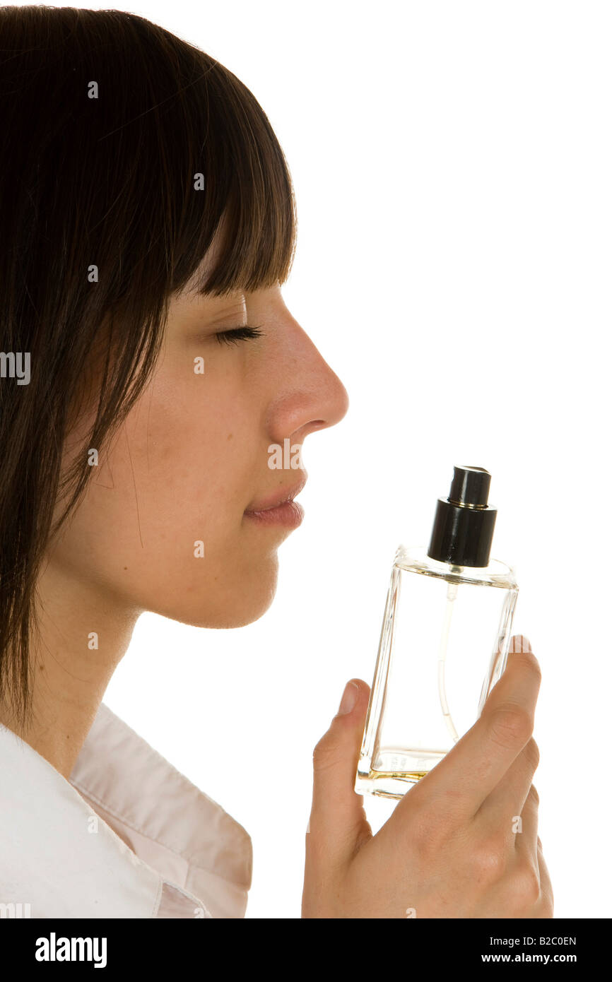 20-year-old woman sniffing a perfume bottle Stock Photo