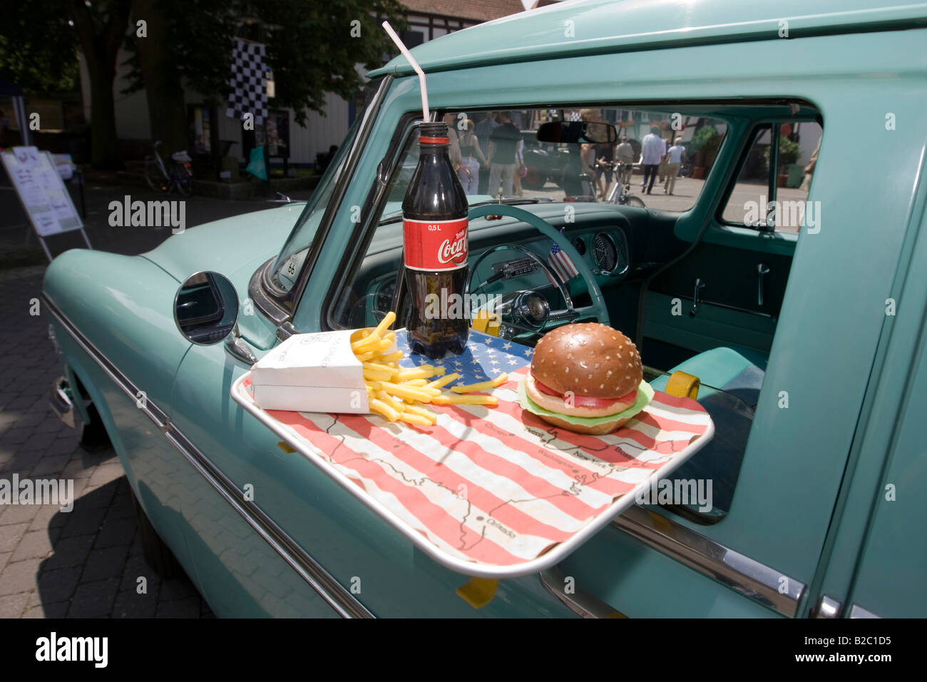 Plymouth Savoy Four 1955, with a tray hanging on the window with a hamburger, a bottle of cola and french fries, Dreieich, Hess Stock Photo