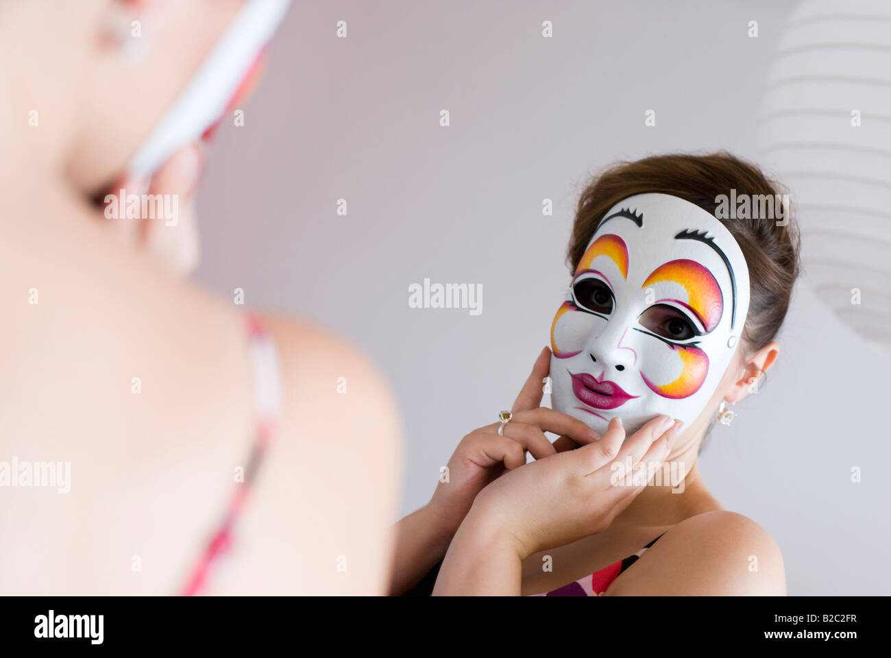 young woman behind mask looking at mirror Stock Photo - Alamy