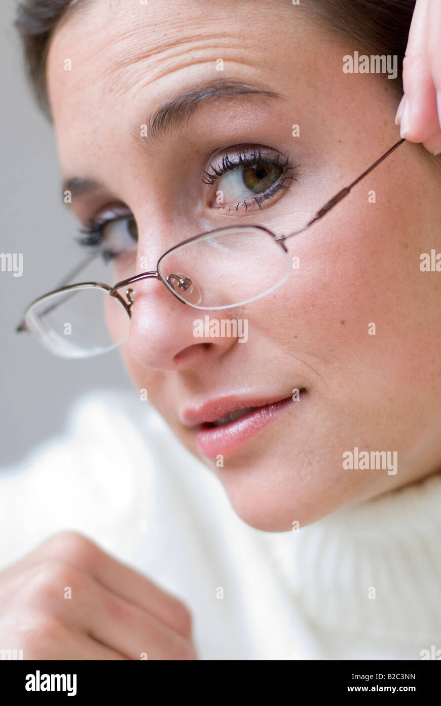 young pretty woman with glasses on the tip of her nose Stock Photo