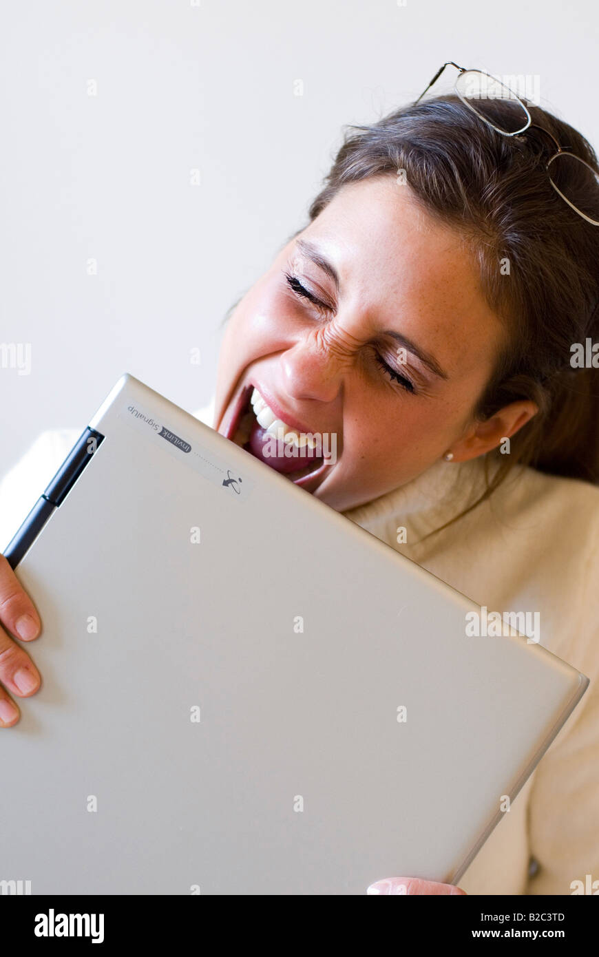 Lady Biting Computer Young woman biting into her notebook Stock Photo - Alamy