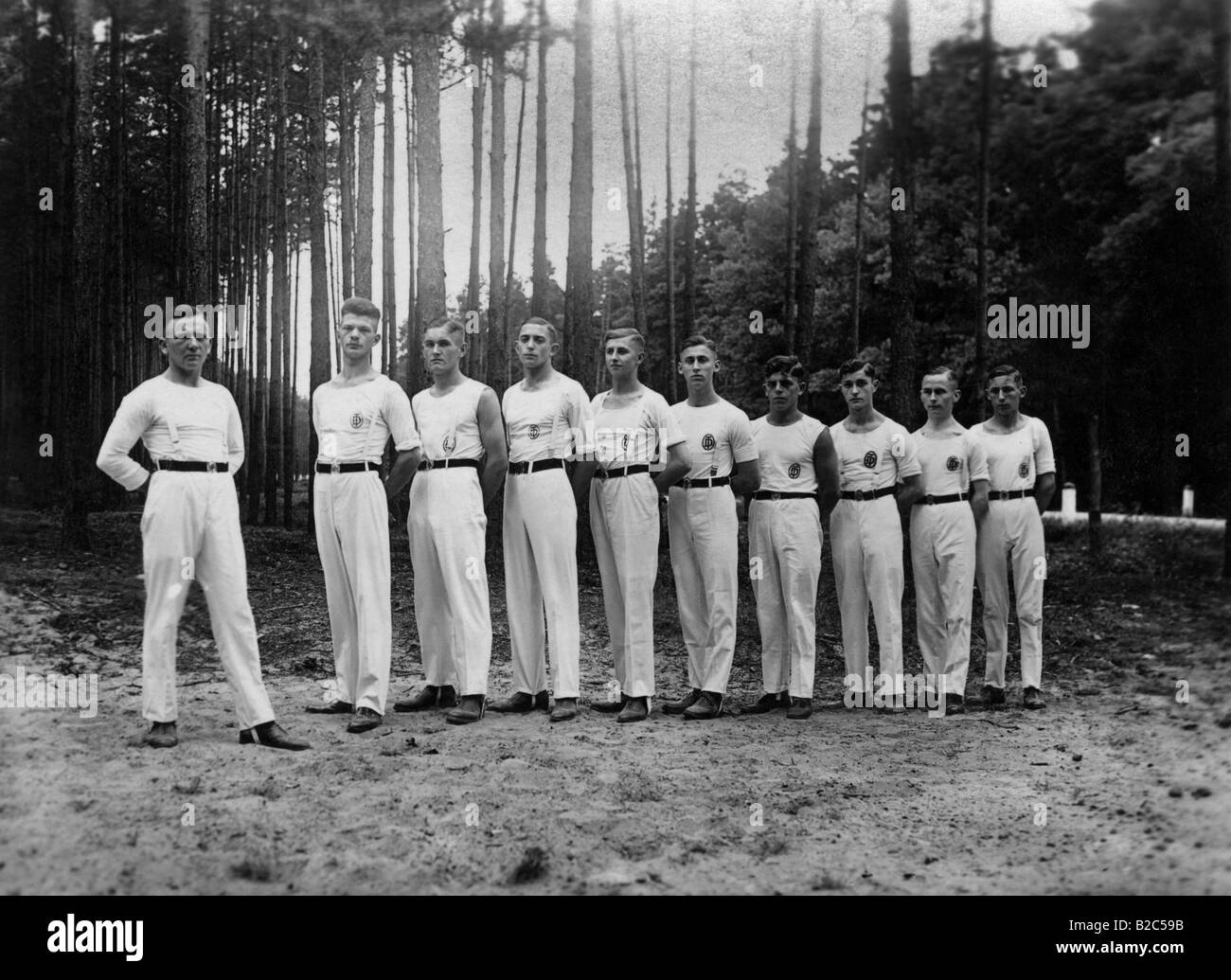 Athletes standing in a row in a forest, historic picture from about 1920 Stock Photo