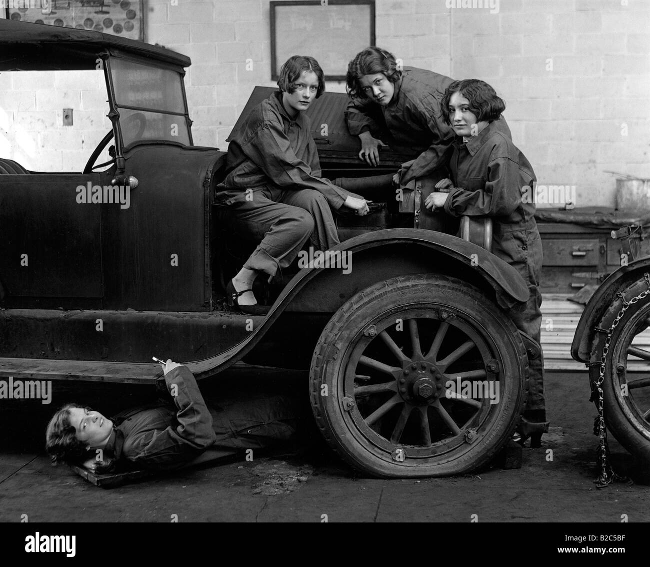 Female car mechanics fixing a car, historic picture from about 1920 Stock Photo