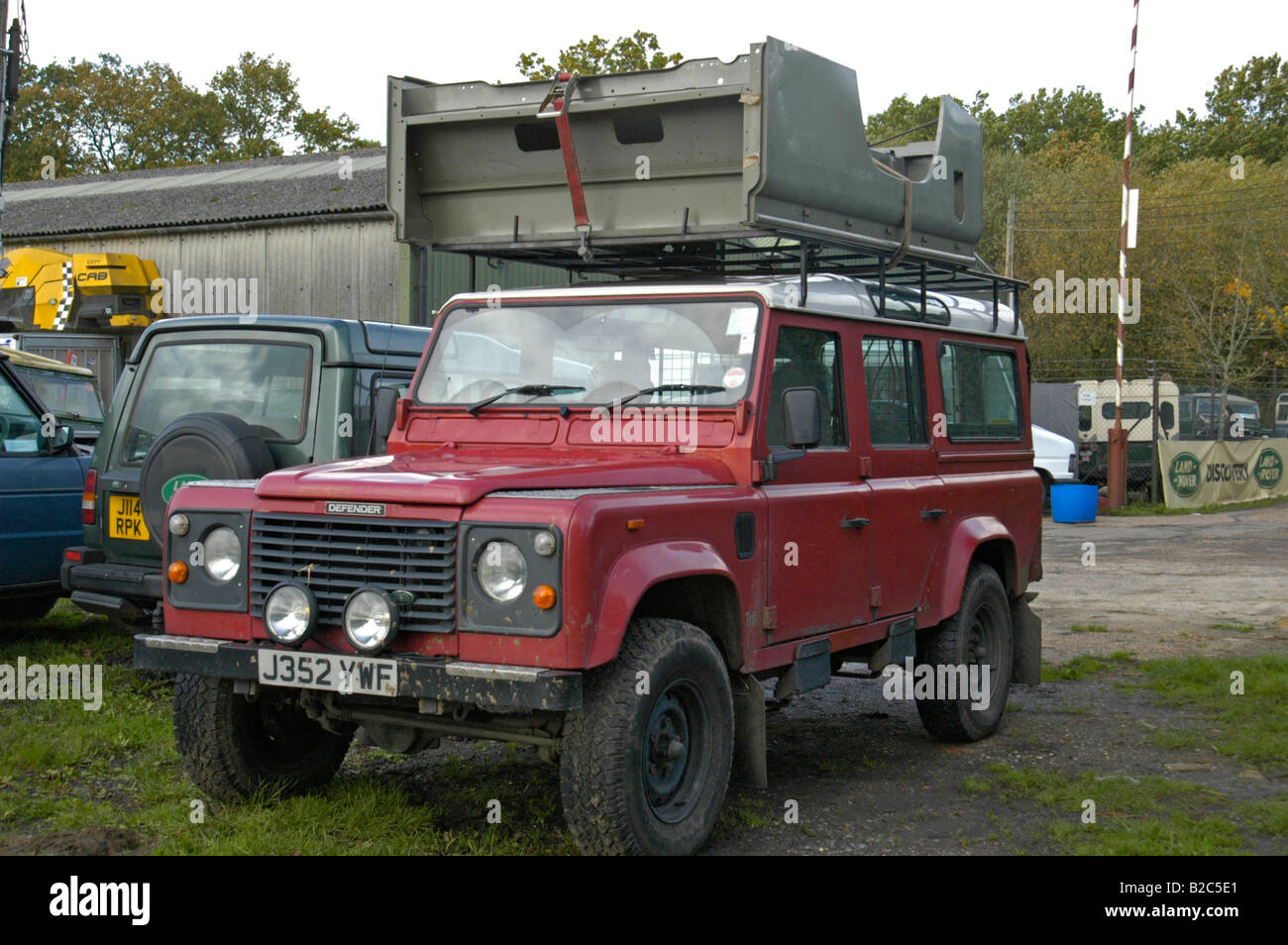 A complete Land Rover 110 HT rear body loaded onto the large roof rack of a Land Rover Defender 110 Station Wagon. Stock Photo