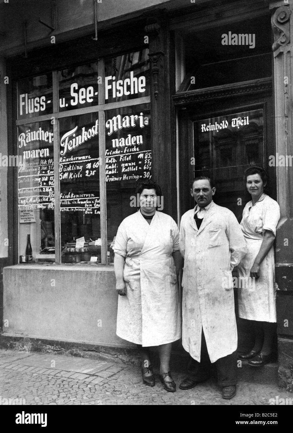 Boss and employees in front of a fish-selling shop, historic picture from about 1920 Stock Photo