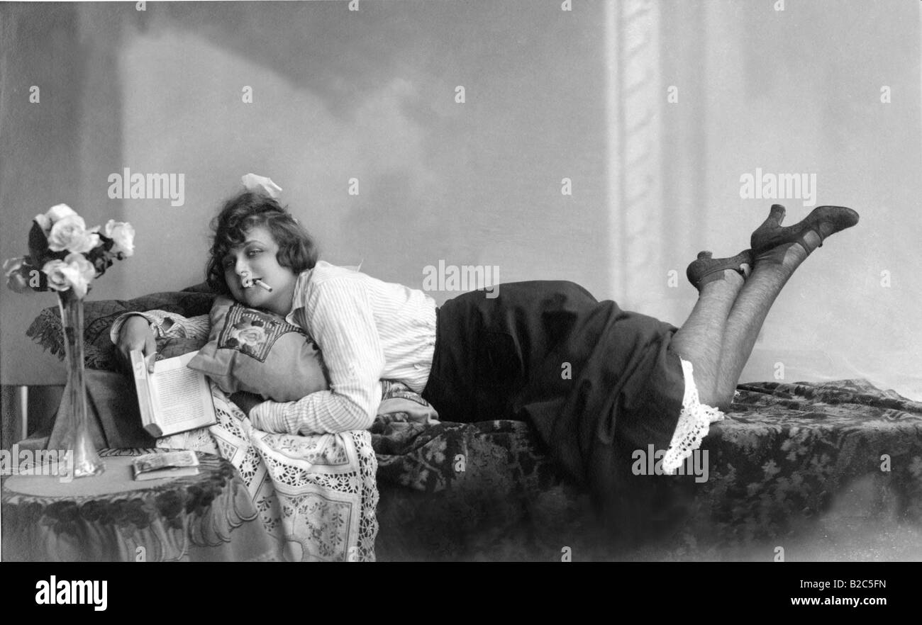 Woman reading and smoking on a divan, historic picture from about 1910 Stock Photo