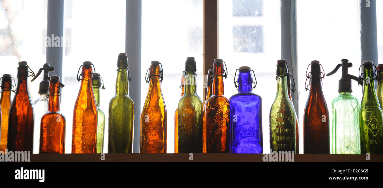 Colourful glass bottles in front of a window Stock Photo