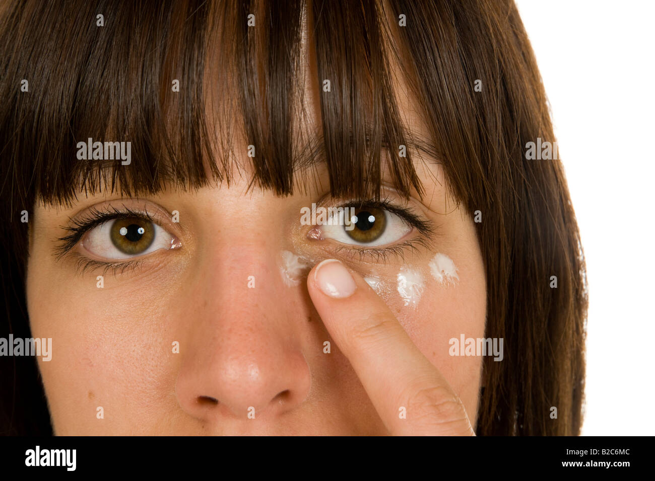 20-year-old woman applying lotion to her face Stock Photo