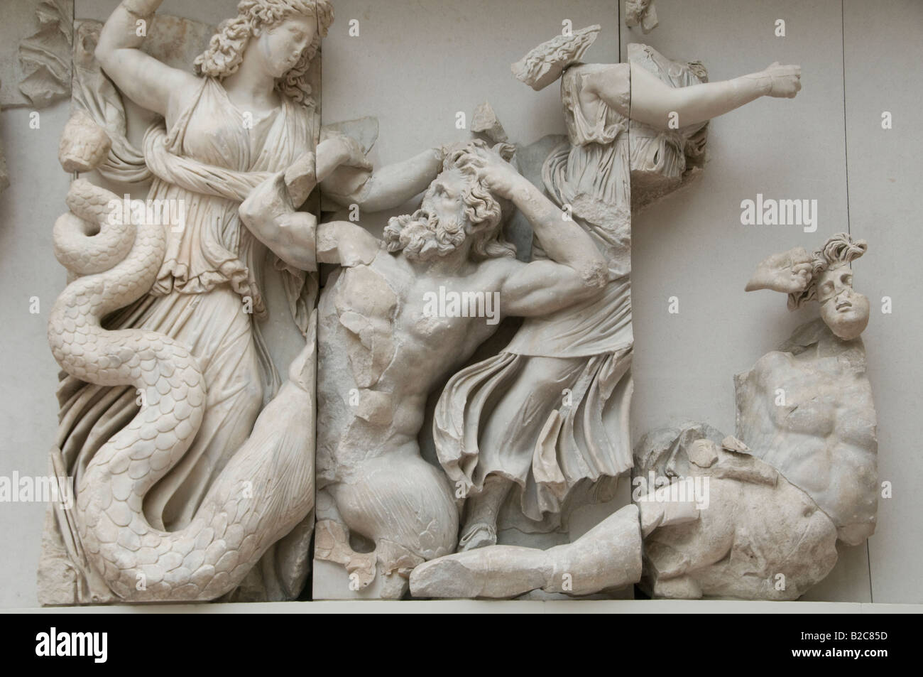 Part of Pergamon Altar depicting the three Moirai club Giants Agrios and Thoas to death in Pergamon Museum in Museumsinsel island Berlin Germany Stock Photo