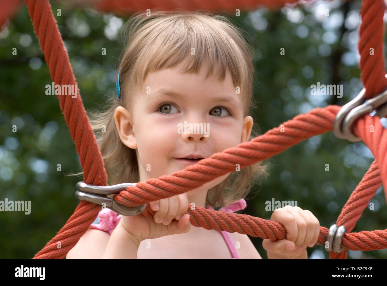 Little Girl at Playground on Rope Monkey Bars Stock Photo