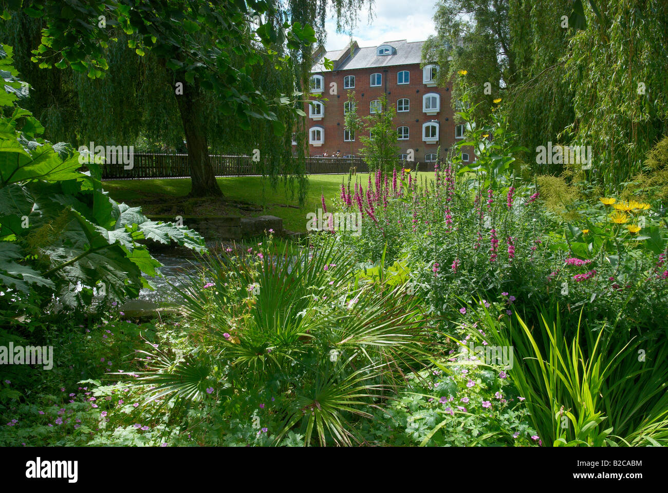 Public gardens along The Weirs in Winchester with Wharf Mill (now flats