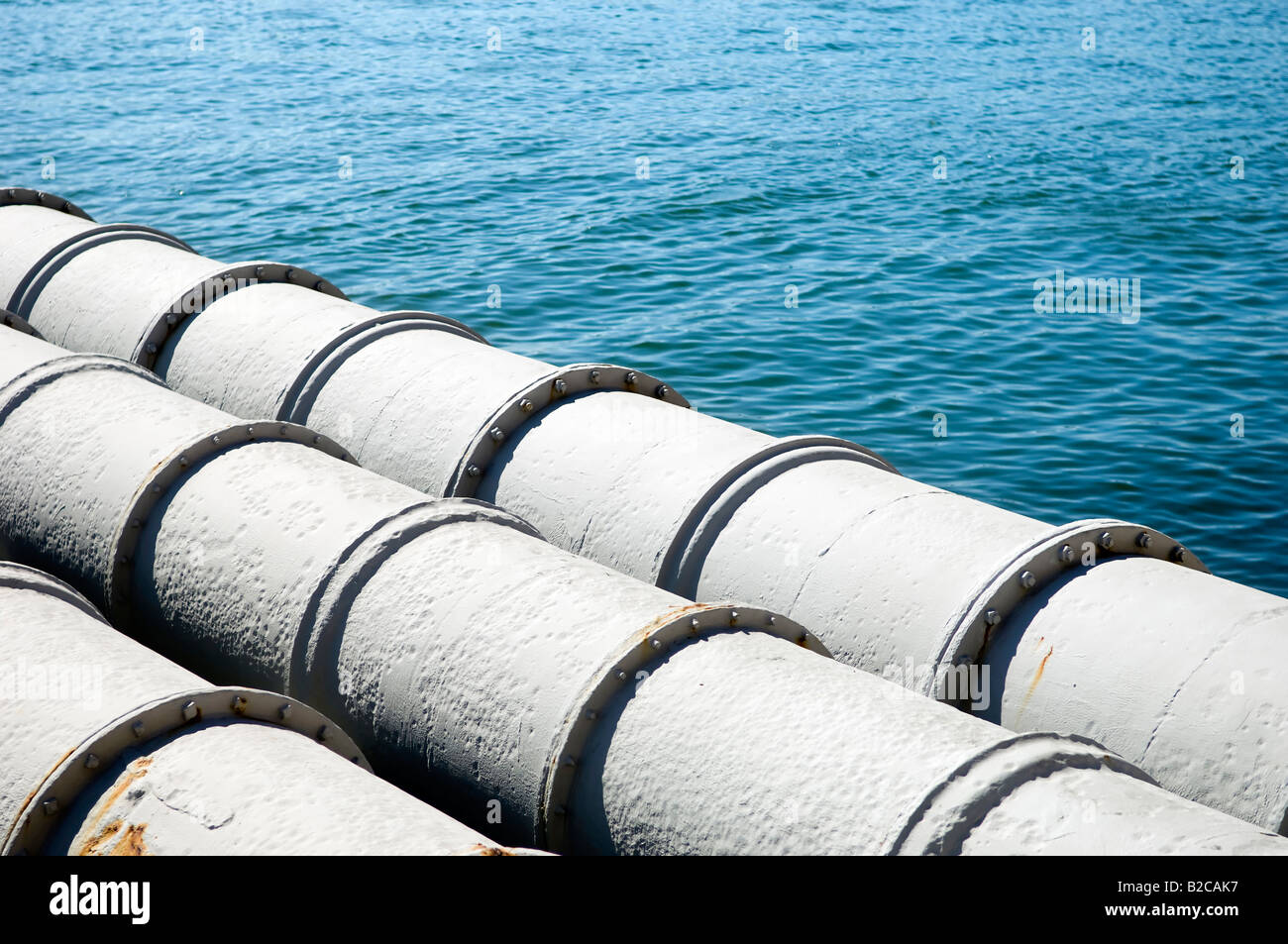 A closeup of large sewage pipes leading out to the sea Stock Photo Alamy