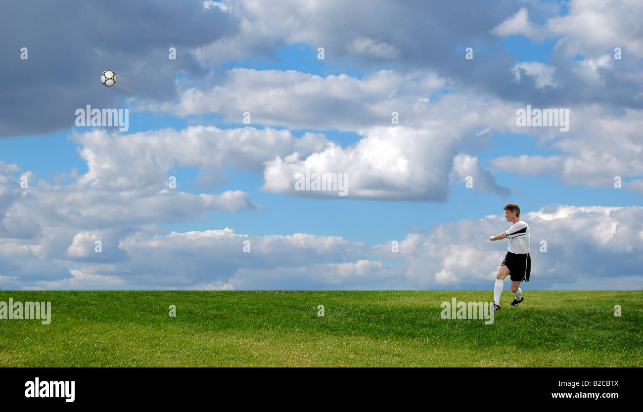 Football Soccer player kicking the ball over a bright sky Stock Photo