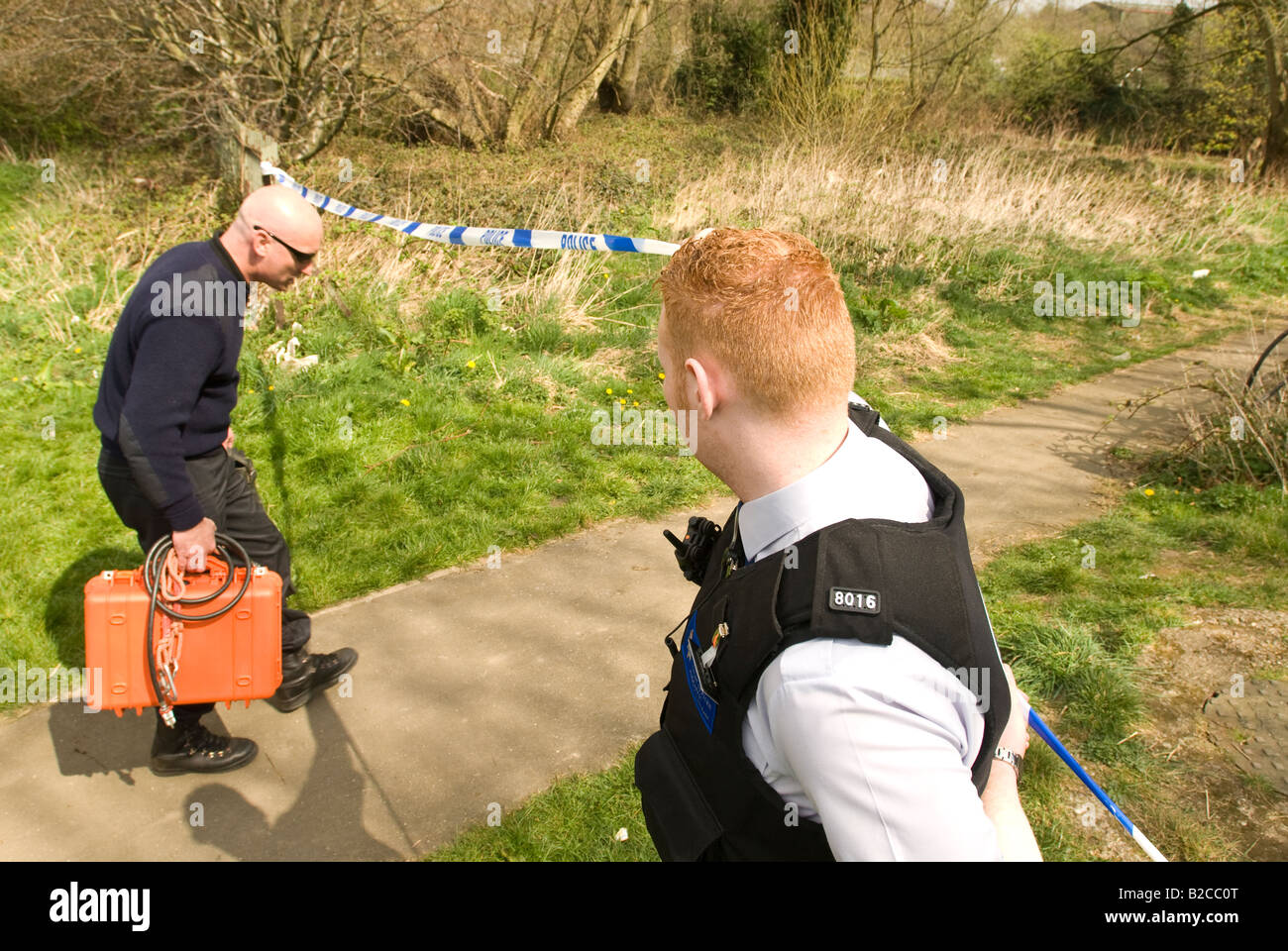 Police set up a security cordon for the underwater search team to look for a weapon used in a murder. Stock Photo