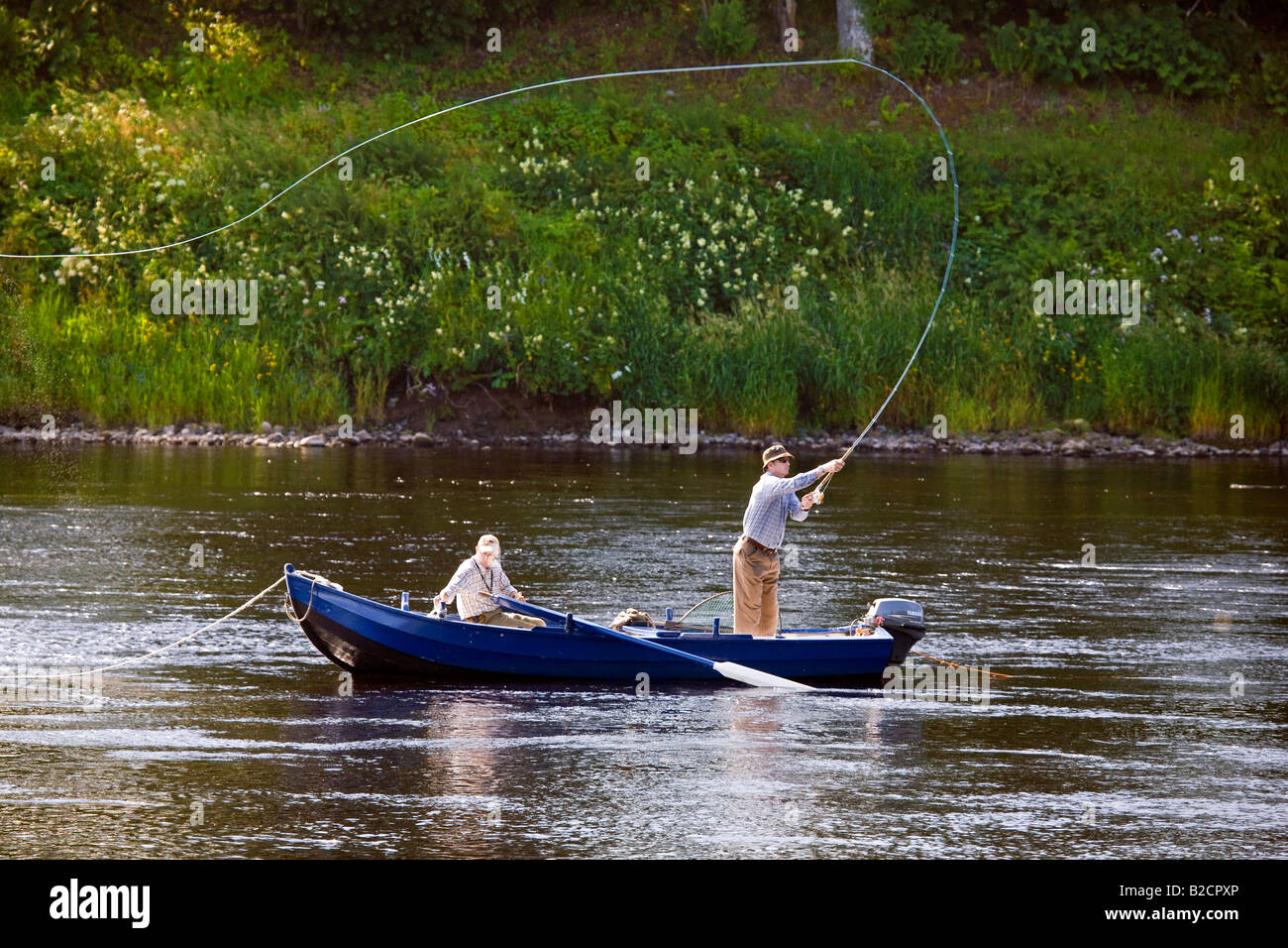 Rowing Boat fisherman, Angler Casting with Fly rod Scottish Salmon Fishing using boats on the River Tay at Ballathie, Tayside, Perthshire, Scotland UK Stock Photo