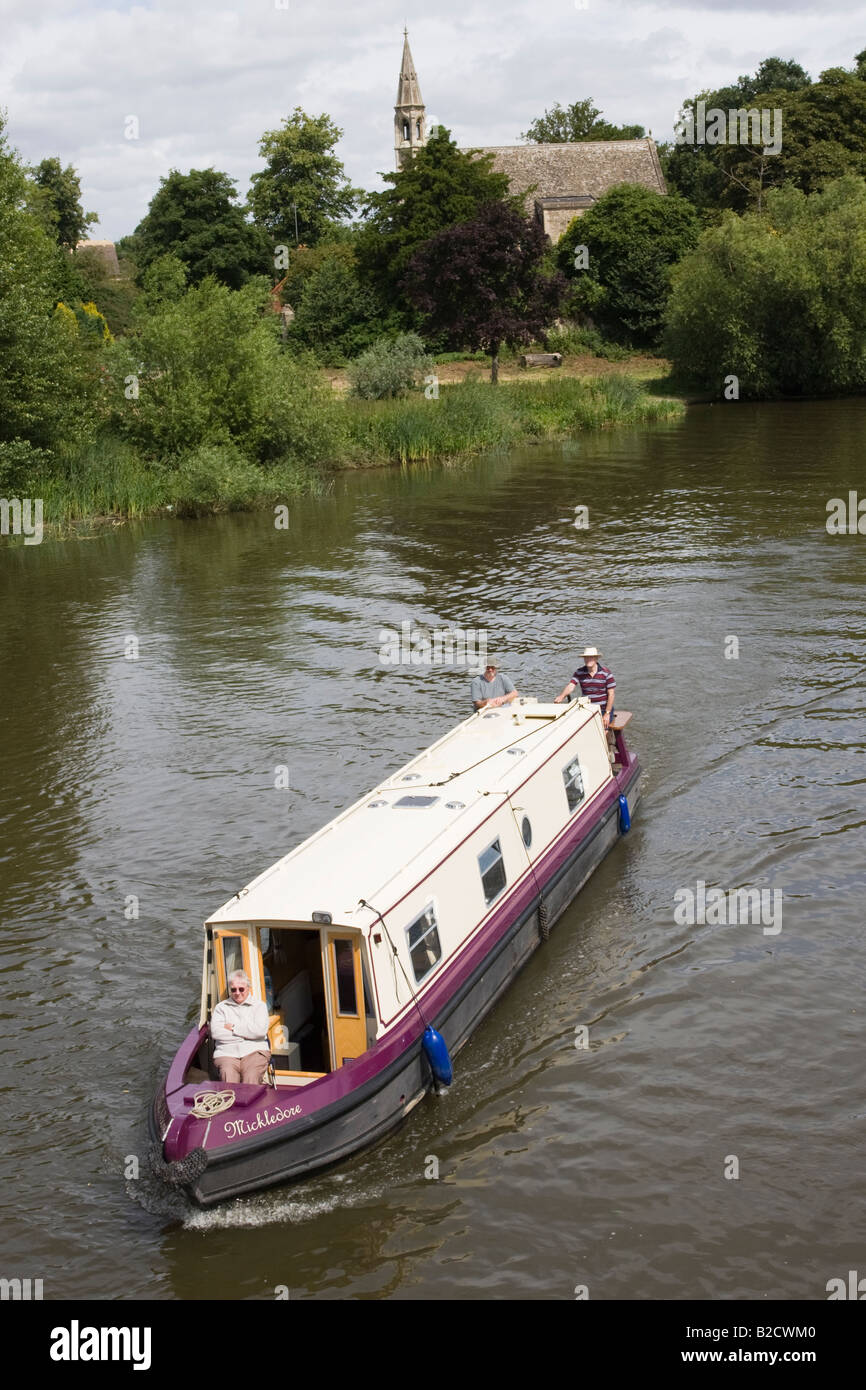 A woman sits on the bow of a canal boat on the Thames at Clifton Hampden Stock Photo