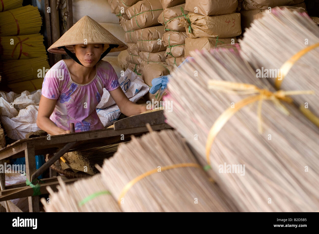 A woman in a conical hat makes incense sticks in Vietnam Stock Photo Alamy