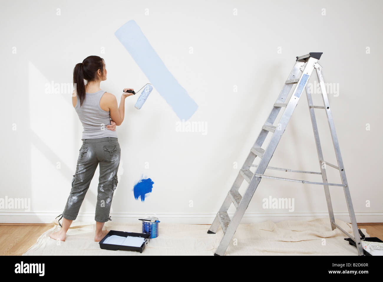 Woman painting wall Stock Photo - Alamy