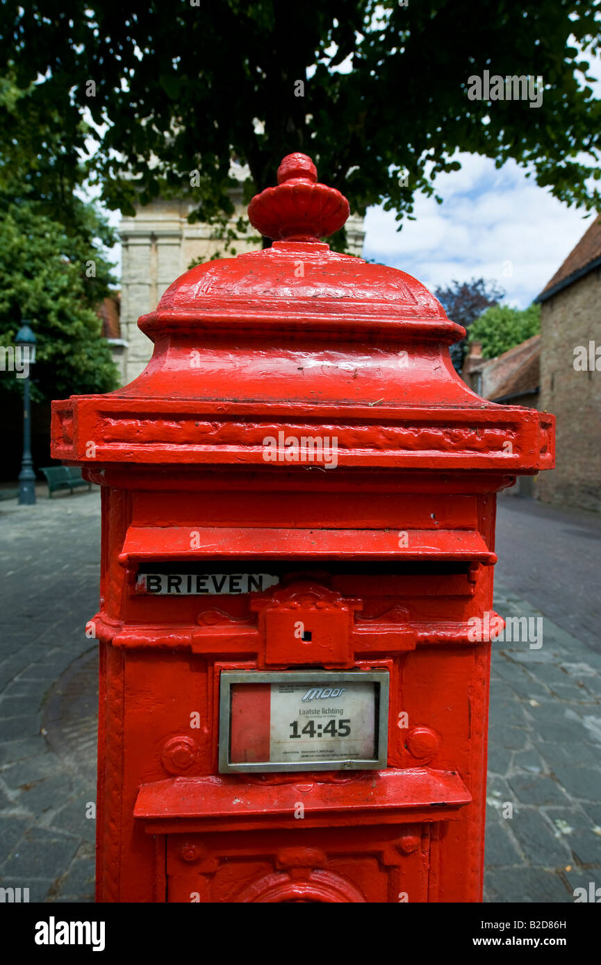 A red postbox on a square in Bruges Stock Photo