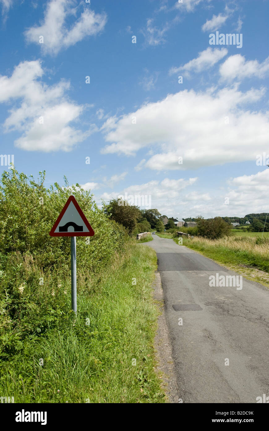 hump backed bridge roadsign on narrow country lane Stock Photo