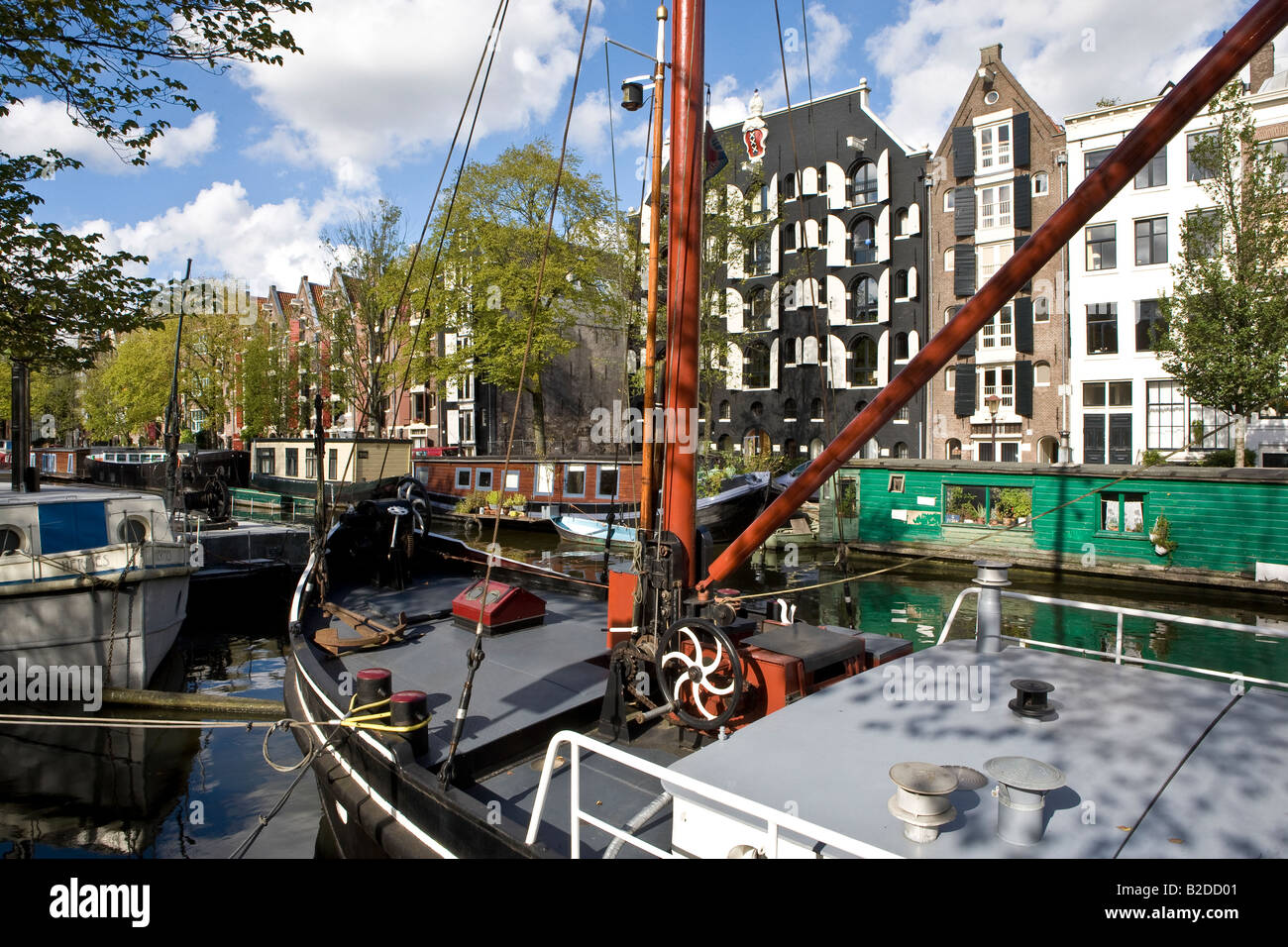 Canalside Scene in Amsterdam, North Holland, Netherlands. Contrasting styles of living in the boat and upmarket apartments Stock Photo