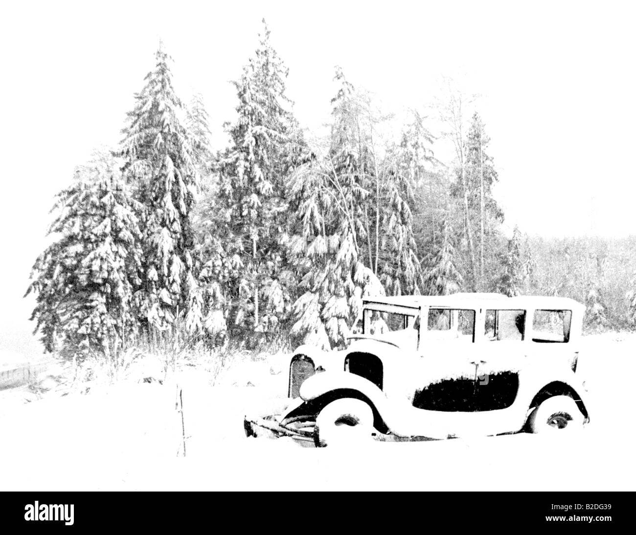 Yesterday's Dream Old Ford Model T Automobile Car sits in the Snow by trees Vintage Stock Photo