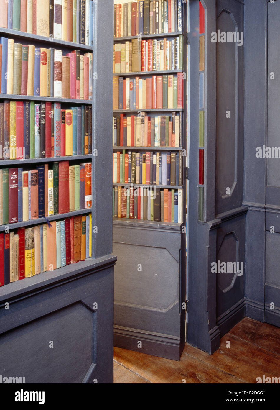 Grey traditional bookshelves with bookshelves on open concealed door
