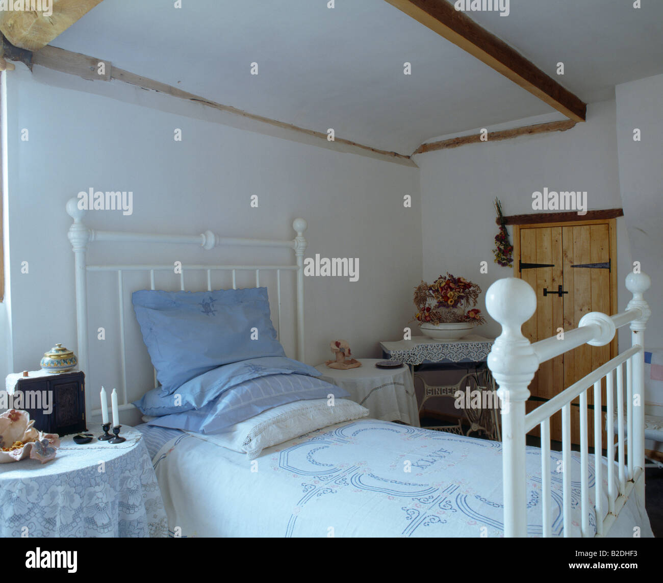 Cottage bedroom with blue pillows and linen on white cast iron