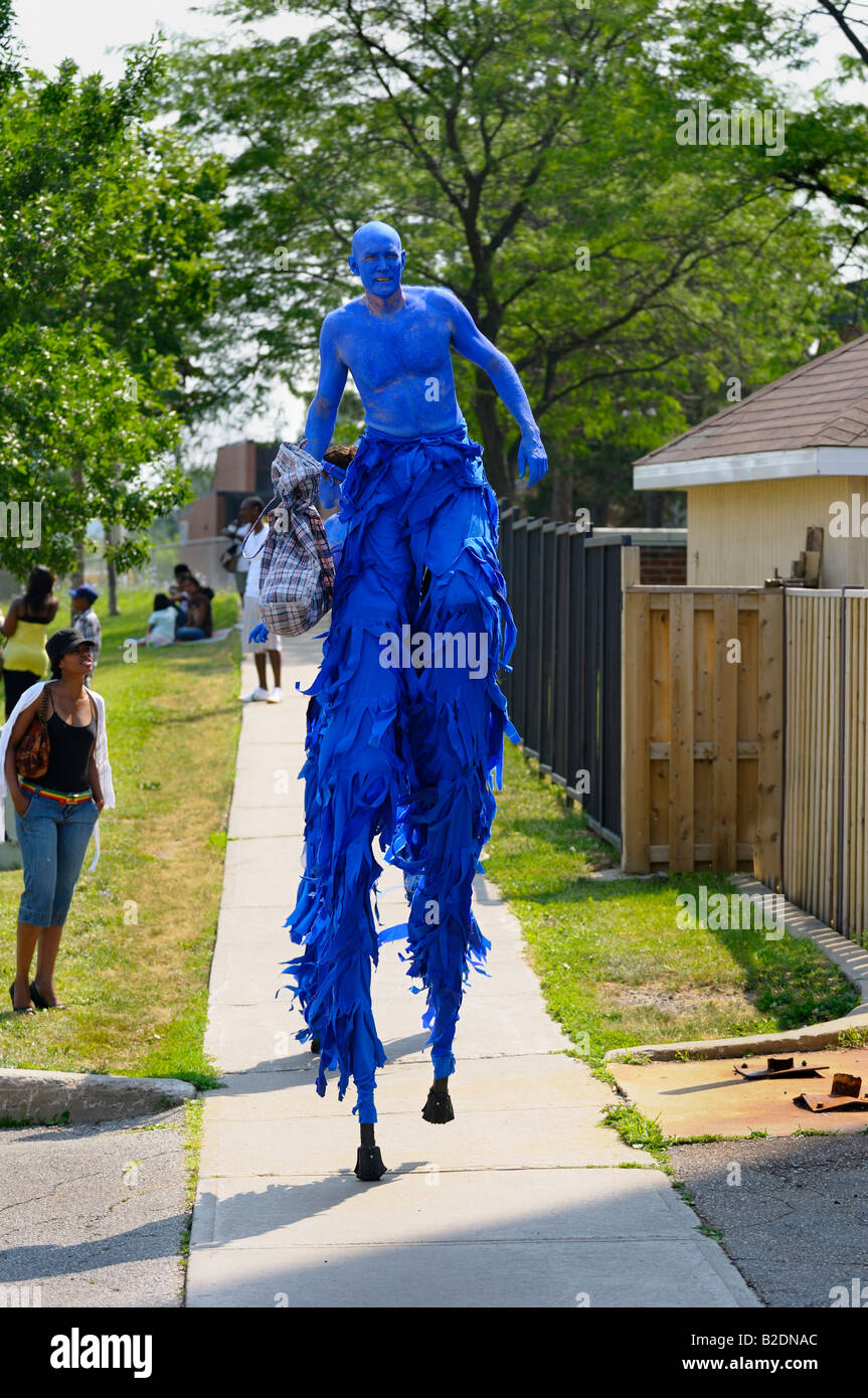 Blue giant walking on stilts on the sidewalk at the Junior Caribana Parade in Toronto 2008 Stock Photo
