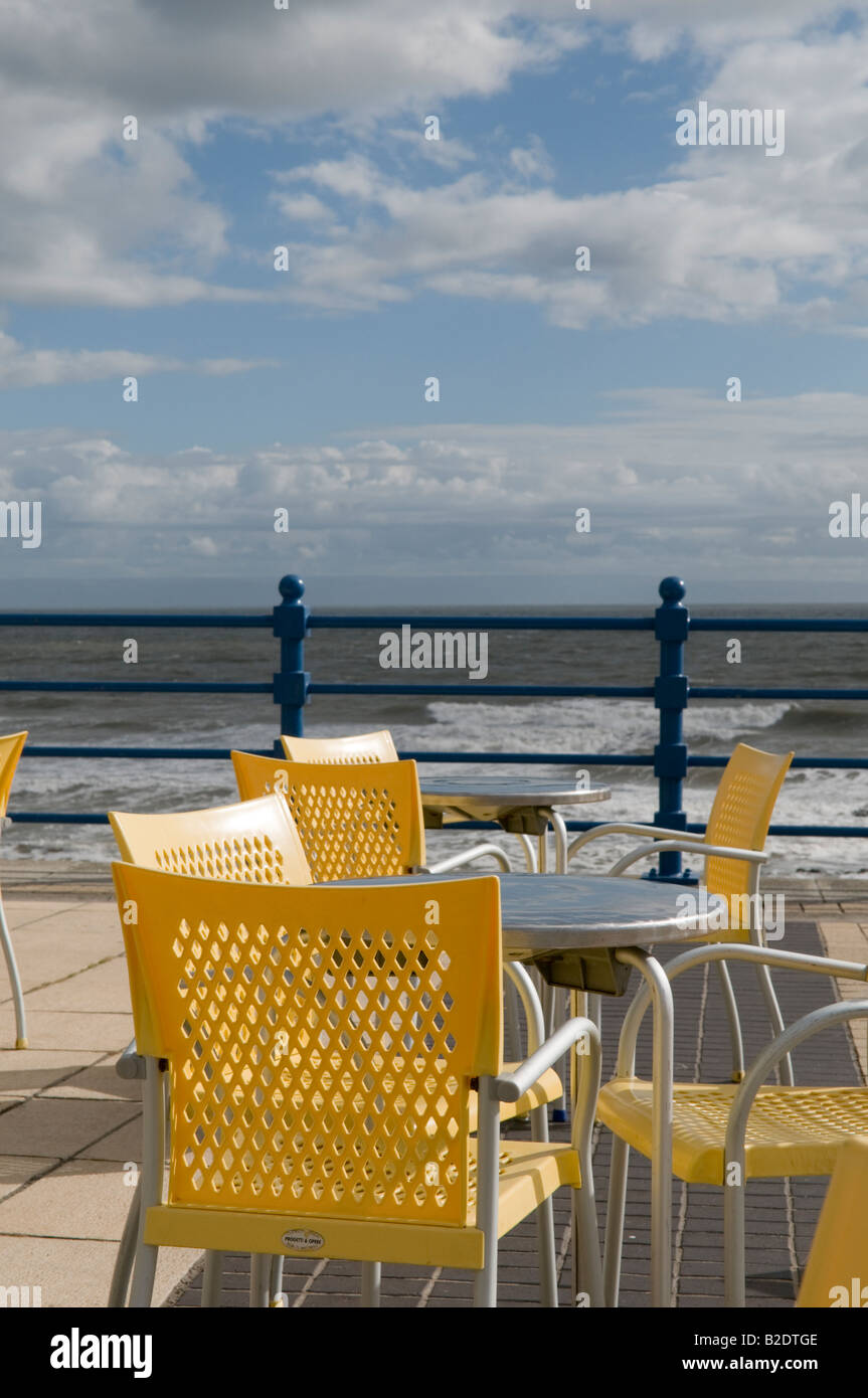 tables and chairs on Porthcawl seafront overlooking the Severn estuary on a windy July afternoon 2008 Stock Photo