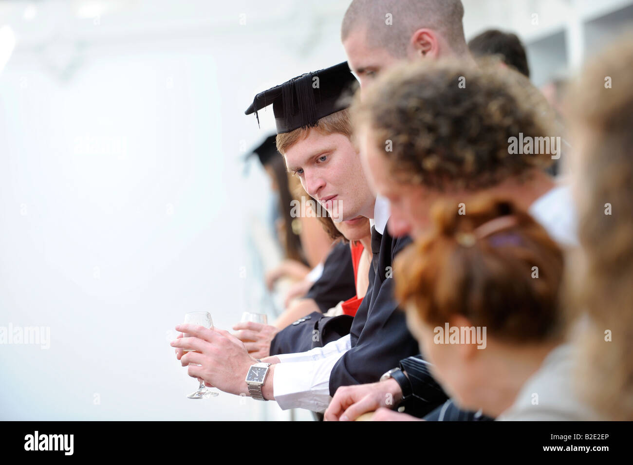 University of Sussex summer graduations at the Brighton Dome - A student looks from the balcony and surveys the hubbub. Stock Photo
