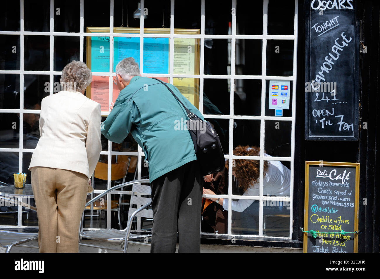 An elderly couple read a menu outside a restaurant in Stratford-upon-Avon. Picture by Jim Holden. Stock Photo
