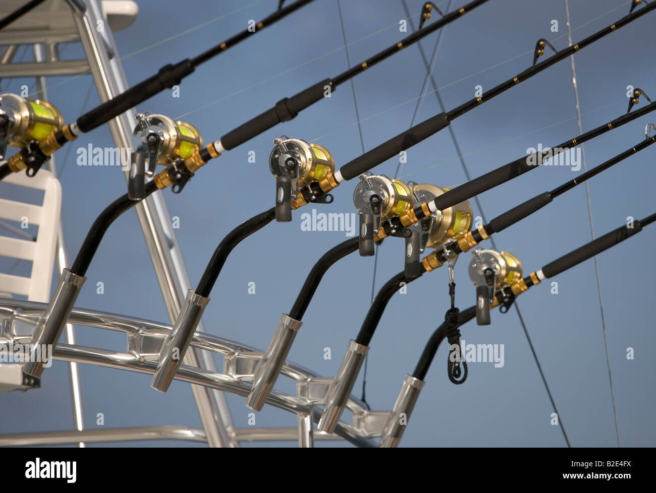 An Array of fishing poles in rod holders on a large commercial charter sport fishing boat Stock Photo