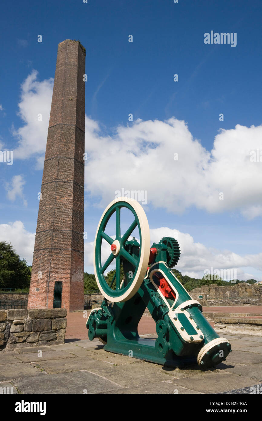 Old industrial engineering machinery artifact on display outside by mill chimney in Burrs 'Country Park' Bury England UK Stock Photo