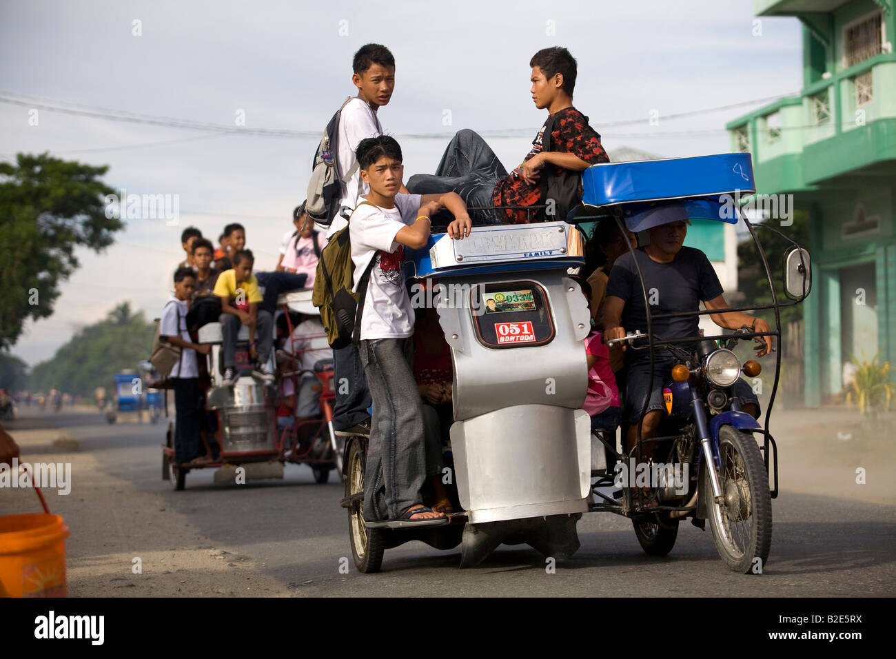 Filipino students ride home from school on tricycle taxis in near Mansalay, Oriental Mindoro, Philippines. Stock Photo