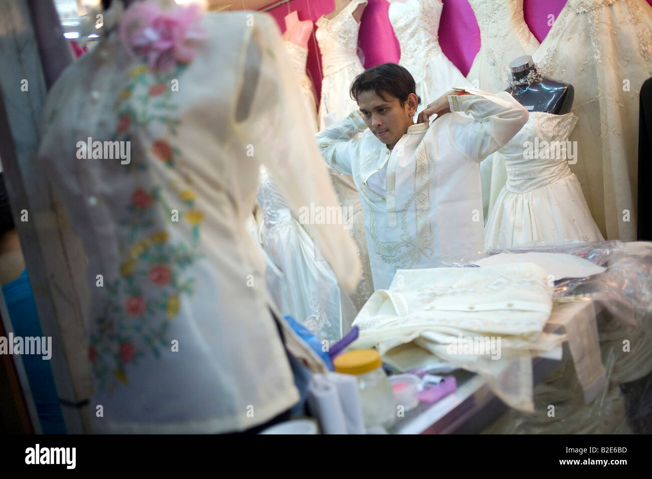 A Filipino tries on a barong in a dressmakers shop in the Divisoria district of Metro Manila, Philippines. Stock Photo